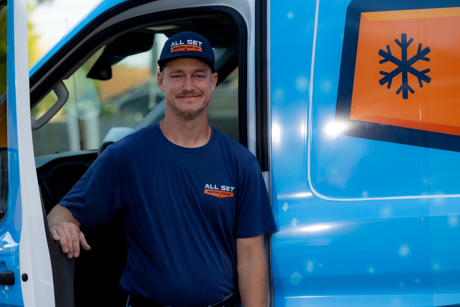 Smiling All Set Heating, Air and Plumbing team member standing by a branded service van in Middleburg, FL