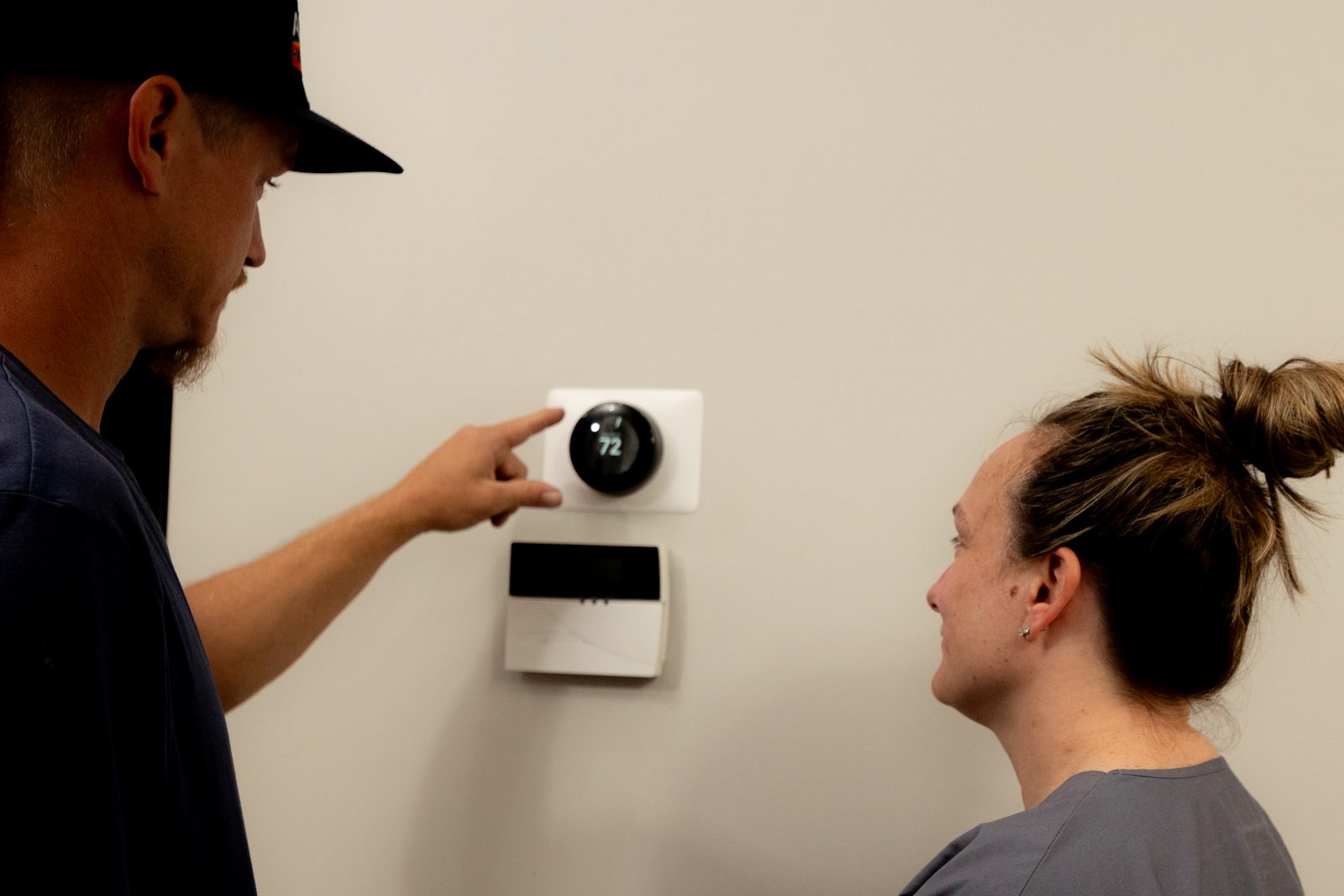 All Set technician explaining an HVAC thermostat to a Northeast Florida homeowner